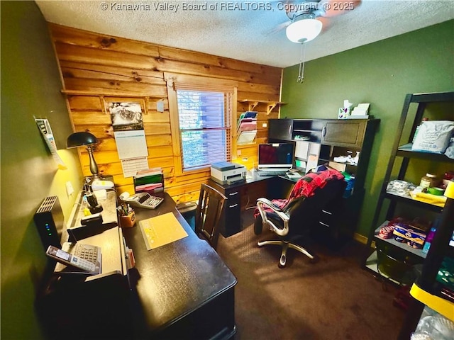 office space with wooden walls, carpet floors, ceiling fan, and a textured ceiling