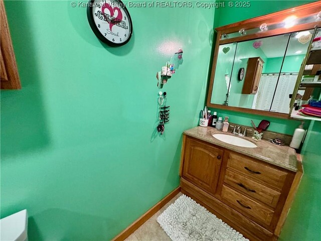 bathroom featuring tile patterned flooring, baseboards, and vanity