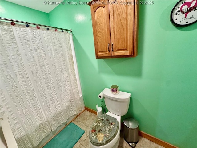 bathroom featuring toilet, tile patterned floors, and baseboards