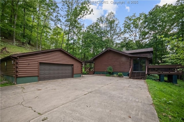 23 Mindia Ln, Alum Creek, WV 25003 - view of front of home featuring a garage, an outdoor structure, a deck, view of scattered trees, and log exterior