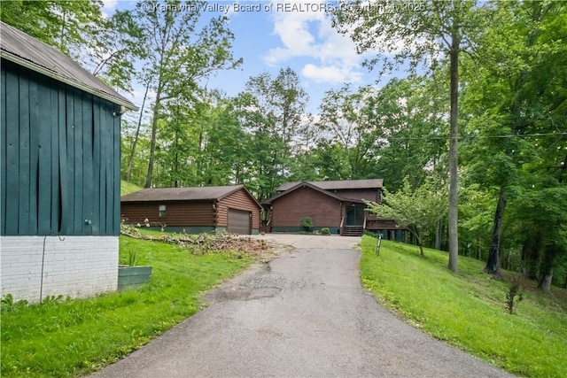23 Mindia Ln, Alum Creek, WV 25003 - view of front of home with an outdoor structure, asphalt driveway, a front lawn, board and batten siding, and a garage