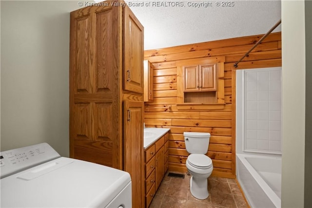 23 Mindia Ln, Alum Creek, WV 25003 - bathroom featuring washer / dryer, toilet, vanity, wood walls, and shower / bathtub combination