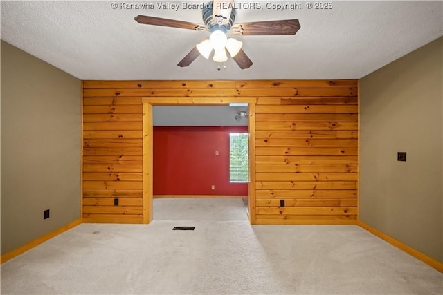 23 Mindia Ln, Alum Creek, WV 25003 - empty room featuring a ceiling fan, carpet flooring, a textured ceiling, baseboards, and wood walls