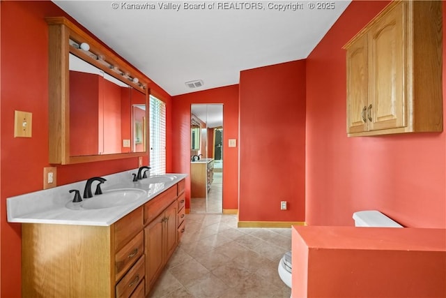 23 Mindia Ln, Alum Creek, WV 25003 - bathroom with double vanity, toilet, baseboards, vaulted ceiling, and tile patterned floors