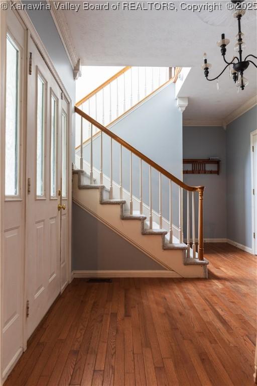 120 Rosewood Dr, Hurricane, WV 25526 - entryway featuring ornamental molding, baseboards, wood-type flooring, stairway, and a chandelier