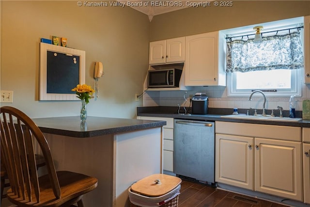 120 Rosewood Dr, Hurricane, WV 25526 - kitchen with appliances with stainless steel finishes, dark countertops, a sink, tasteful backsplash, and white cabinetry