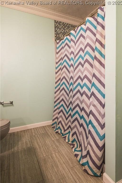 120 Rosewood Dr, Hurricane, WV 25526 - bathroom featuring crown molding, toilet, baseboards, and curtained shower