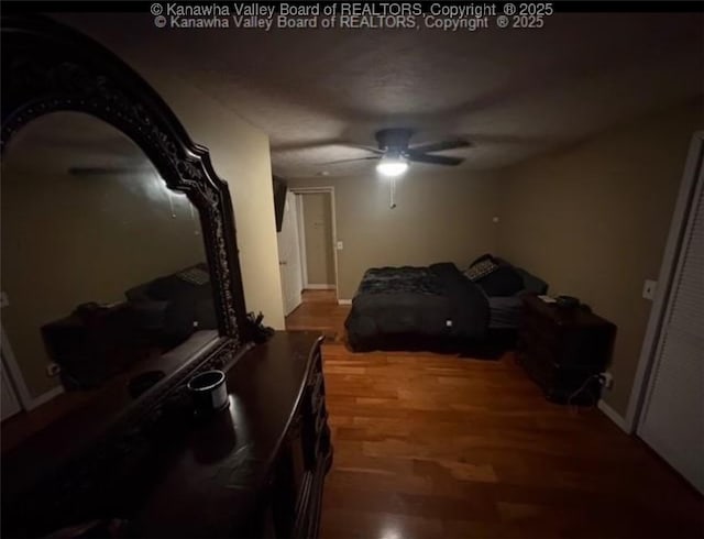 bedroom with a ceiling fan, wood finished floors, and baseboards