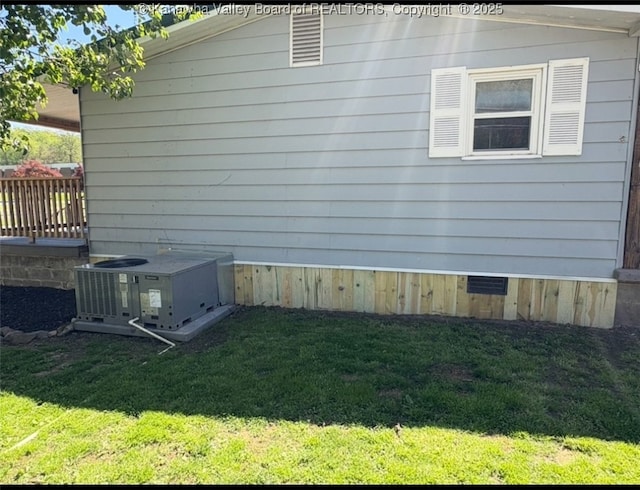 view of home's exterior with a lawn and central AC unit