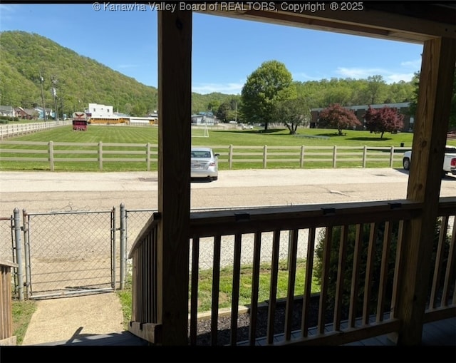 exterior space featuring a mountain view, fence, and a gate