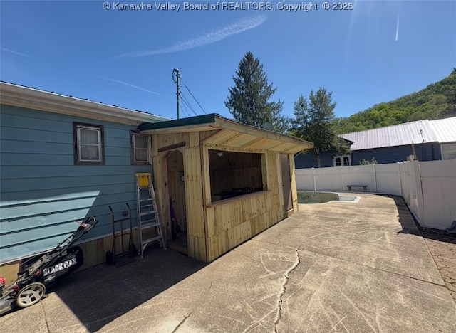 view of outbuilding featuring fence