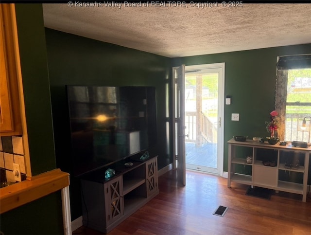 living room featuring a textured ceiling and wood finished floors