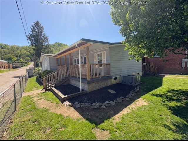 view of front of home with a front yard, crawl space, central AC, and fence
