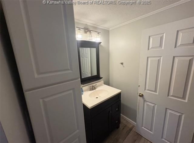 bathroom featuring a textured ceiling, wood finished floors, vanity, and crown molding