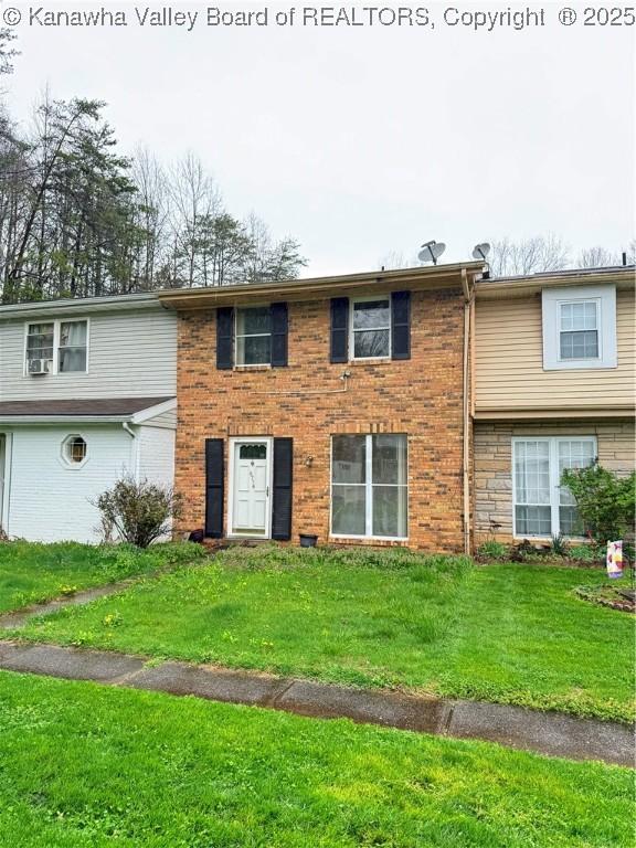 view of front of home with a front yard and brick siding