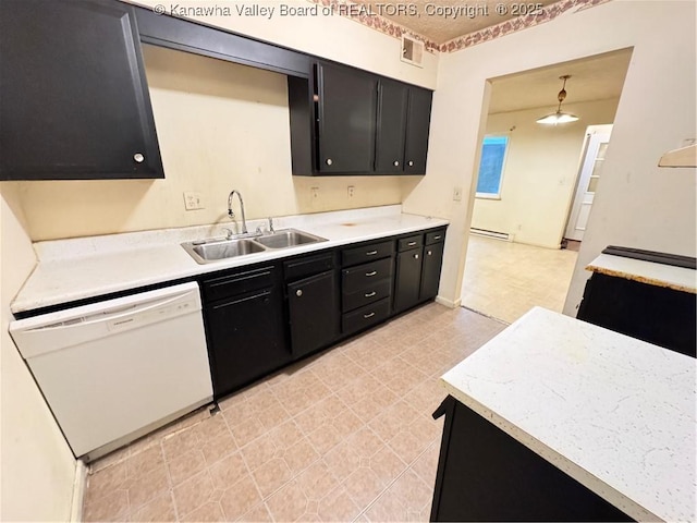 kitchen featuring dark cabinets, visible vents, dishwasher, light countertops, and a sink