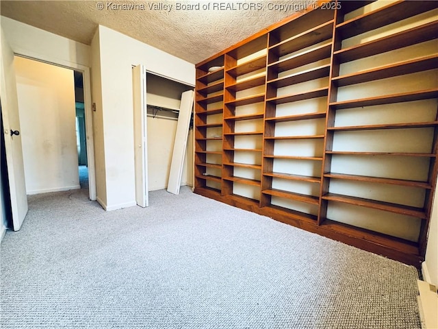 unfurnished bedroom featuring a closet, baseboards, carpet flooring, and a textured ceiling