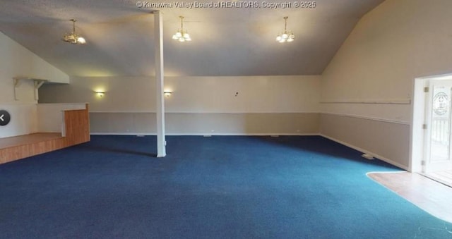 bonus room with an inviting chandelier, carpet flooring, and vaulted ceiling