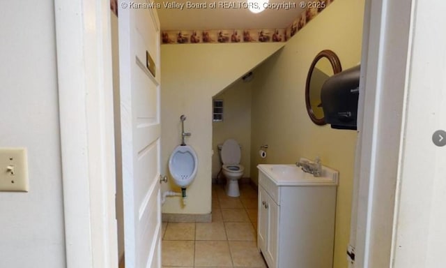 bathroom featuring toilet, tile patterned flooring, and vanity
