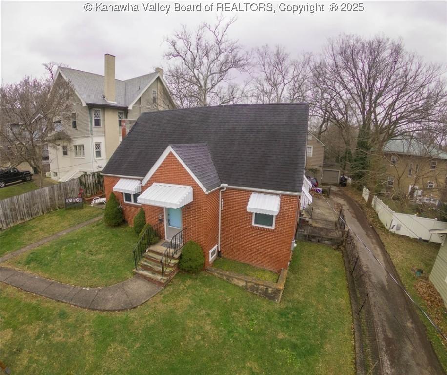 846 Somerset Dr, Charleston, WV 25302 - view of front of property with roof with shingles, a fenced backyard, a front lawn, and brick siding