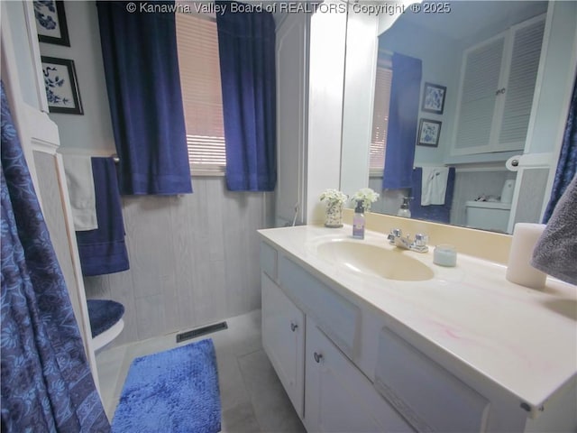 bathroom featuring visible vents, toilet, vanity, and tile patterned flooring