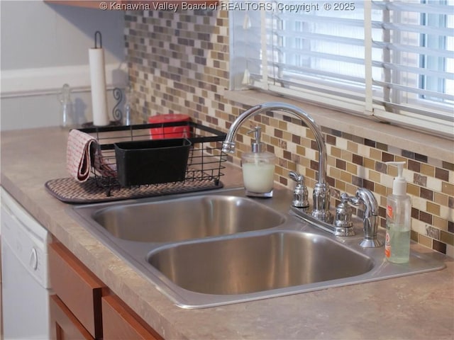 interior details with a sink, brown cabinetry, tasteful backsplash, and dishwasher