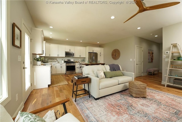 living room featuring recessed lighting, light wood-style floors, baseboards, and ceiling fan