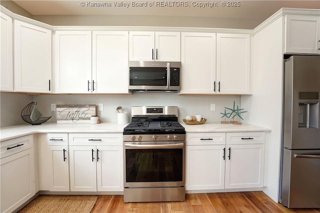 kitchen featuring light wood-style flooring, white cabinetry, and stainless steel appliances