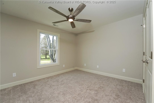 carpeted spare room featuring visible vents, baseboards, and a ceiling fan