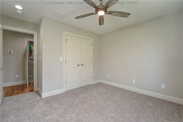 unfurnished bedroom featuring a closet, baseboards, a ceiling fan, and carpet