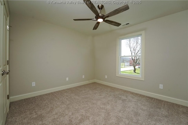 carpeted spare room featuring visible vents, baseboards, and a ceiling fan