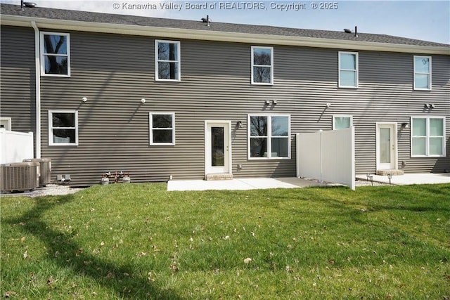 rear view of house with central AC, fence, a patio, and a lawn