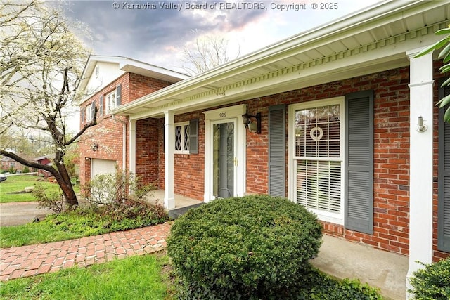 906 Hughes Dr, Saint Albans, WV 25177 - property entrance featuring a garage, a porch, and brick siding