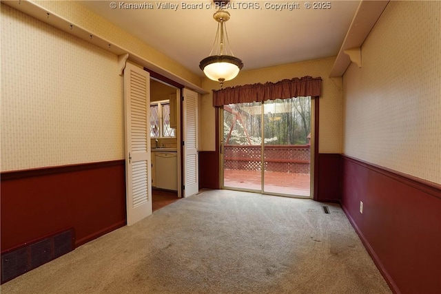 906 Hughes Dr, Saint Albans, WV 25177 - carpeted empty room with visible vents, a sink, wallpapered walls, and a wainscoted wall