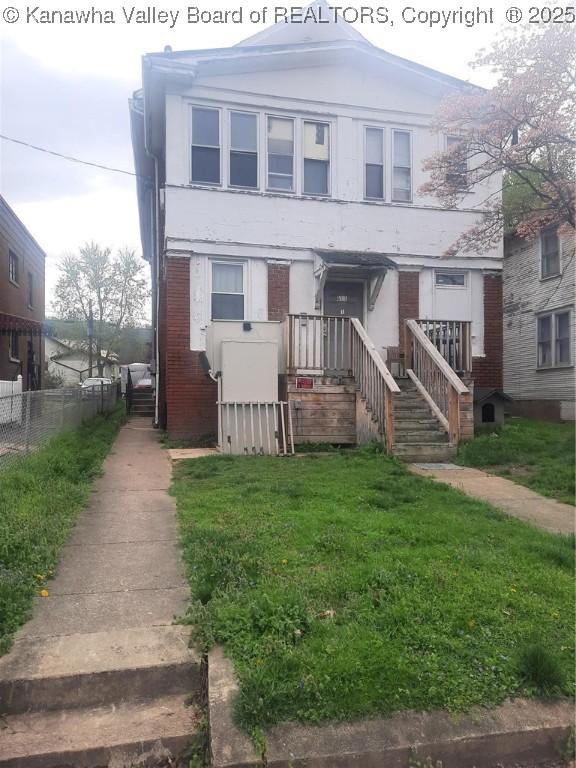 view of front of house featuring a front lawn and fence