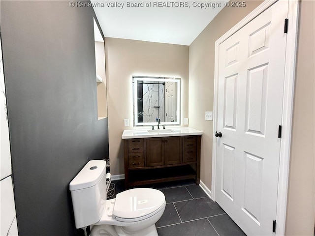 bathroom featuring tile patterned flooring, vanity, baseboards, and toilet