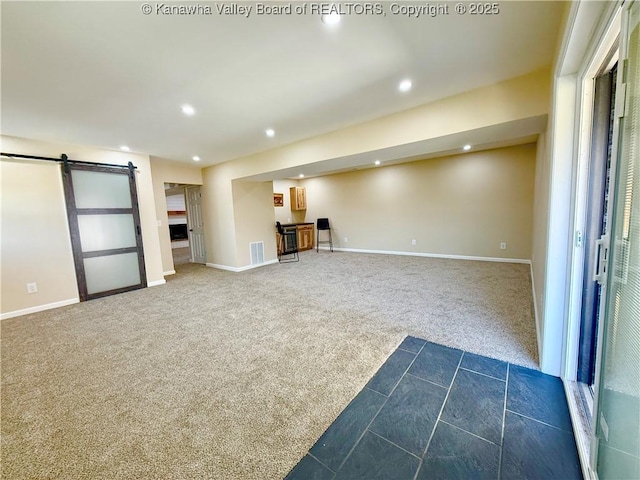 interior space featuring baseboards, recessed lighting, dark colored carpet, and a barn door