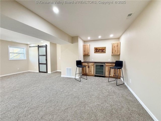 interior space featuring a dry bar, visible vents, a barn door, light carpet, and wine cooler