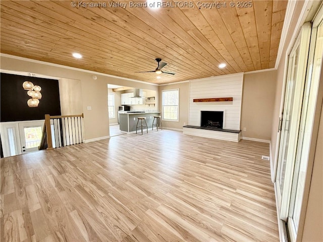 unfurnished living room with light wood finished floors, ceiling fan with notable chandelier, wooden ceiling, and crown molding