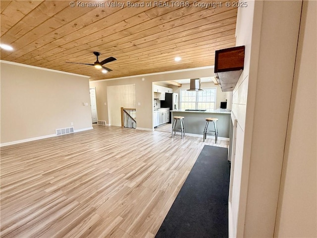 unfurnished living room featuring visible vents, baseboards, ornamental molding, light wood-type flooring, and wood ceiling
