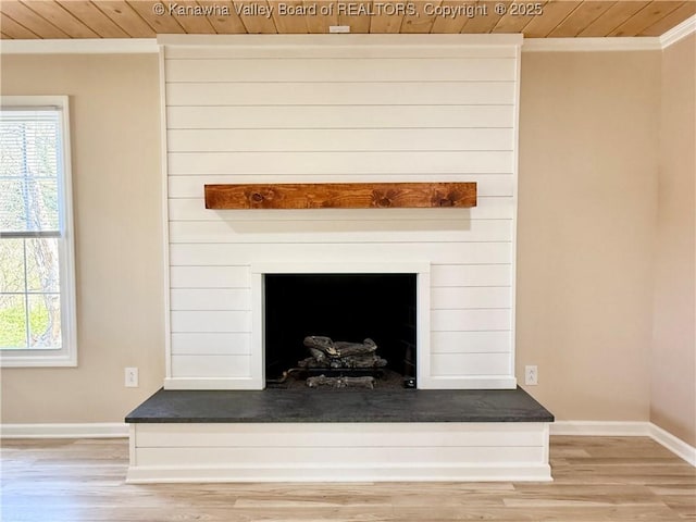 interior details with baseboards, a fireplace, crown molding, wood ceiling, and wood finished floors