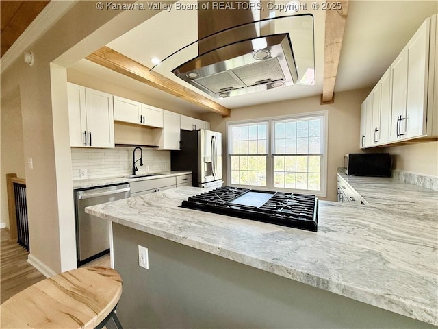 kitchen with white cabinetry, a sink, backsplash, and appliances with stainless steel finishes