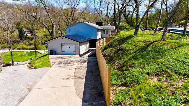 219 Westmoreland Dr, Dunbar, WV 25064 - view of property exterior featuring concrete driveway, a garage, and a lawn