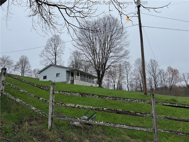 view of yard featuring fence and a rural view