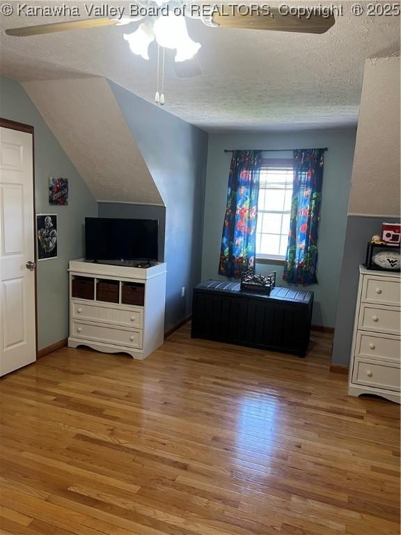 bedroom featuring a textured ceiling, ceiling fan, wood finished floors, and lofted ceiling