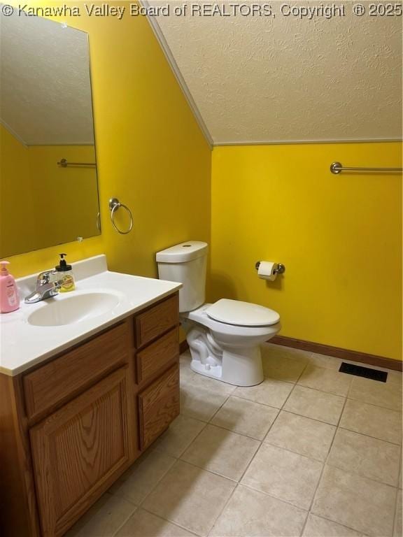 bathroom with a textured ceiling, tile patterned flooring, vanity, toilet, and lofted ceiling