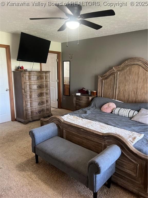 carpeted bedroom with a ceiling fan and a textured ceiling