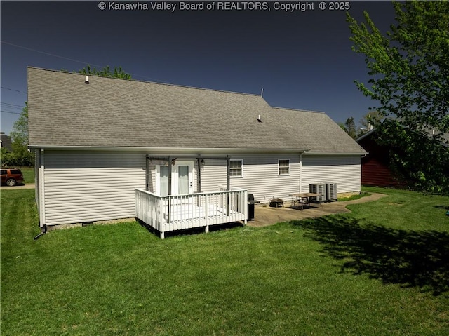 back of house featuring a wooden deck, a shingled roof, and a yard