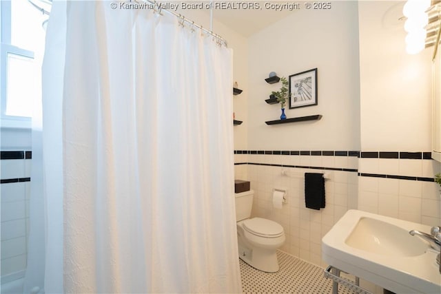 12 Arlington Ct, Charleston, WV 25301 - bathroom with tile patterned flooring, a wainscoted wall, toilet, tile walls, and a sink