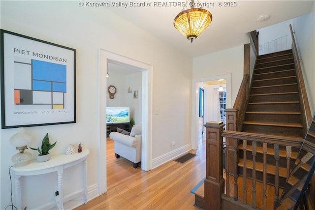 12 Arlington Ct, Charleston, WV 25301 - hallway featuring visible vents, baseboards, stairway, and light wood-style floors